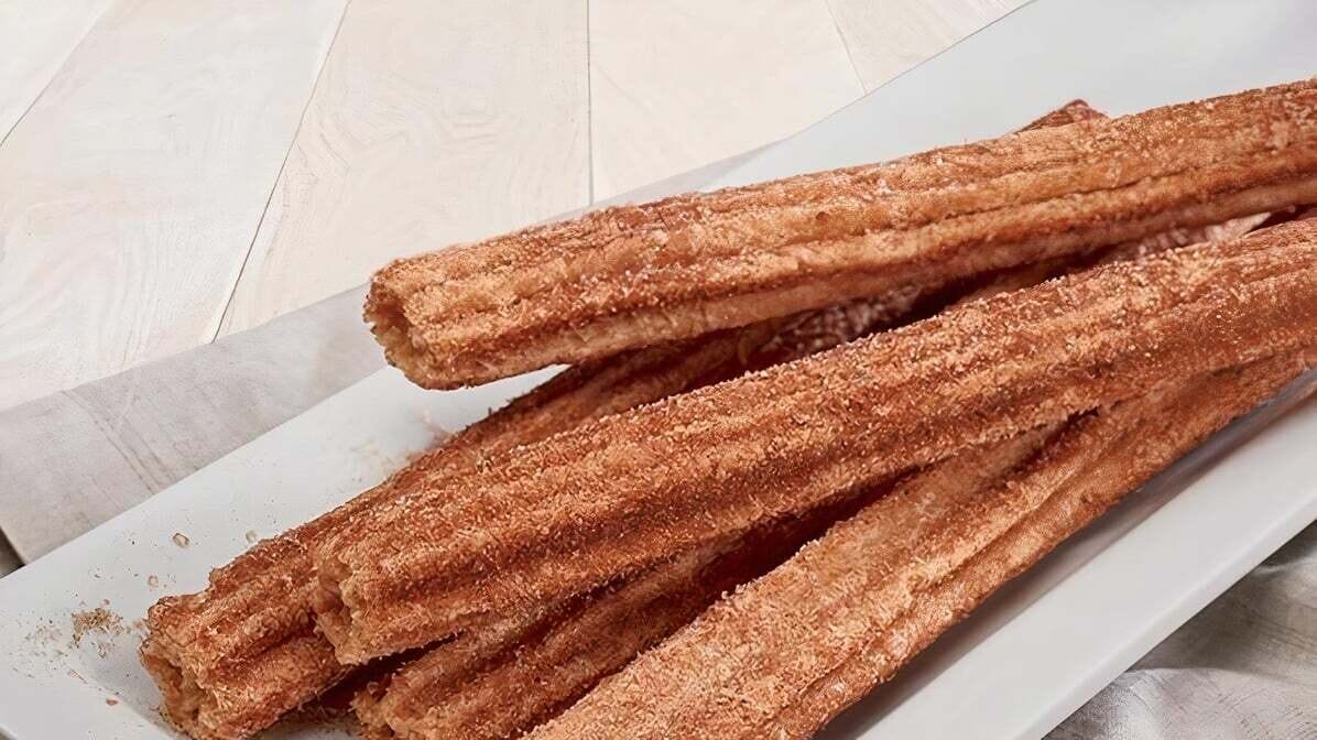Indulge in the sweet delight of Atwater Street Tacos' Churro - a crispy fried dough dessert coated in sugar and cinnamon, with an optional upgrade of creamy fudge drizzle. Order now for a taste of authentic Mexican sweetness!