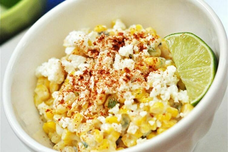 A plate of Esquites, a traditional Mexican dish with sautéed sweet corn, chorizo, herbs, spices, shredded cheese, and lime, served at Atwater Street Tacos.