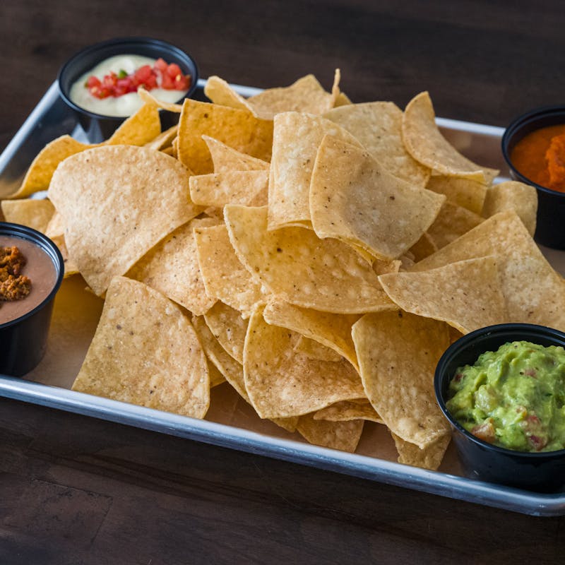 Chip Flight with house-made chips and four dips including guacamole, queso, chorizo bean, and salsa at Atwater Street Tacos in Flat Rock MI