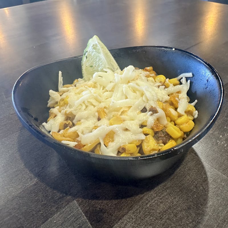 Bowl of Esquites Mexican street corn topped with chorizo, shredded cheese, and lime, served at Atwater Street Tacos in Monroe, Michigan and Flat Rock, Michigan